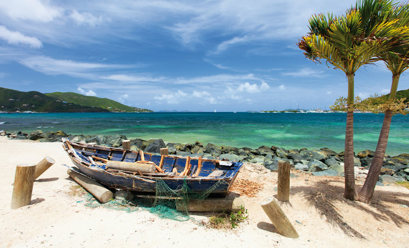 strand met oude boot op het strand van Tortola